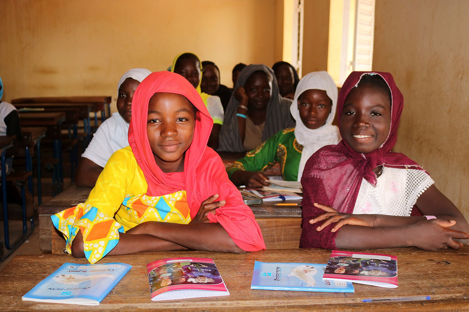 Bambine felici studiando nelle scuole gestite da Plan International